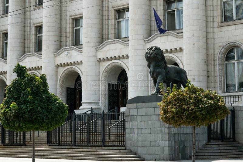 Arvokas kivirakennus, jonka edessä on suuri leijonapatsas ja EU-lippu.